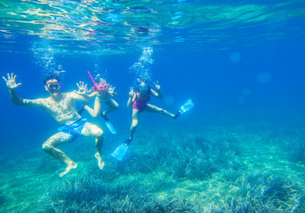 Fototapeta na wymiar Family dives into the sea in masks