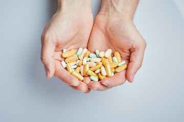 Fototapeta premium Hand of a young man holding a pills