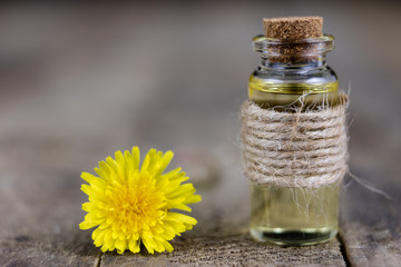 Syrup with dandelion on a wooden table. Cure for colds from natural ingredients.