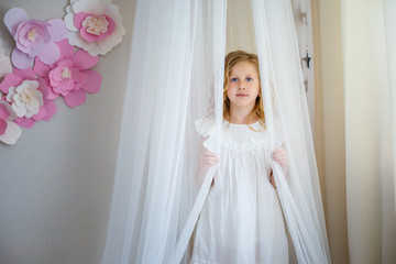 Fototapeta na wymiar Cute little girl dreams of becoming a princess