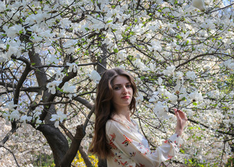 Young girl in beautiful magnolias tree garden