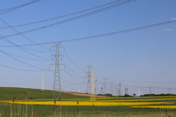 High voltage electric lines cross the hilly mestnost. Electric station in the summer under the open...