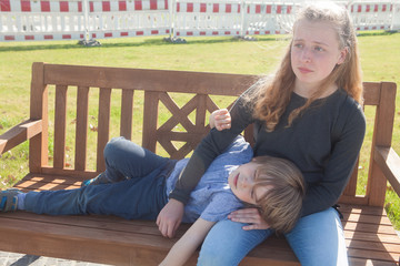 Girl angry with her little brother lying on her