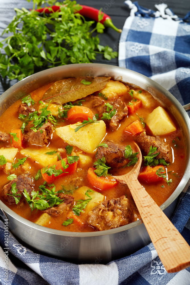 Poster beef stew with vegetables in pot