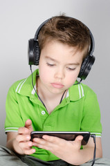 Kind schaut Smartphone und hört Musik