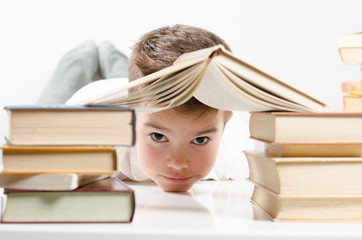 Kind schaut unter dem Buch die als Dach dargestellt ist