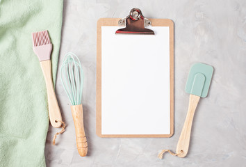 Paper clipboard with empty space and kitchen utensils top view