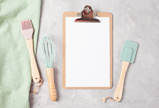 Paper clipboard with empty space and kitchen utensils top view