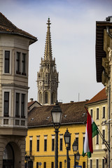 A street in Budapest, Buda part, a view of the spire of St.Matthias church and some lanterns,...