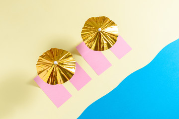 Top view of yellow sand beach with gold sun umbrellas and colorful sun beds on seaside. Minimal summer concept.