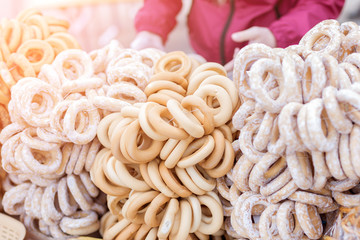 Traditional pastry dried bagels with powdered sugar at market or fair. Sweet homemeade bakery