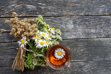 cup of herbal chamomile tea with fresh daisy flowers on wooden background. doctor treatment and prevention of immune concept, medicine - folk, alternative, complementary, traditional medicine 