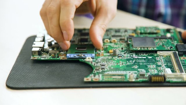 microelectronics workshop courses. computer repair. technician removing cpu from motherboard socket