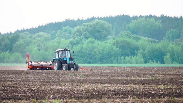 Tractor works plows the field before planting the harvest in slow motion