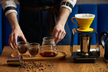 Barista prepare coffee at bar counter using different glassware and utensil, close-up