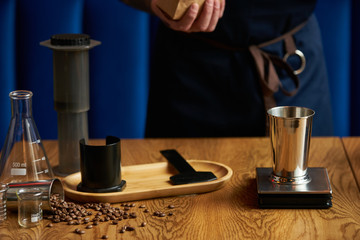 Barista prepare coffee at bar counter using different glassware and utensil, close-up