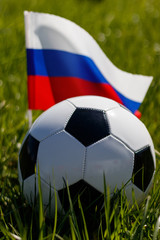 Fototapeta premium Soccer ball on the grass and the Russian flag