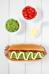 Chilean Completo Italiano (Italian) traditional hot dog sandwich, made of bread, sausage, tomato, avocado and mayonnaise, photographed overhead with natural light (Selective Focus on the hot dog)