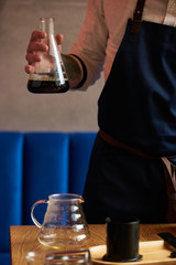 Professional barista preparing coffee alternative method, close-up