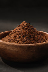 close up of cocoa powder in wooden bowl on table