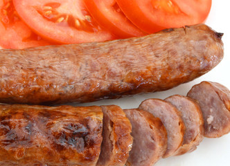 Frie sausage and slice tomato on white