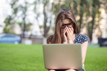 student woman sitting down behind her laptop in campus