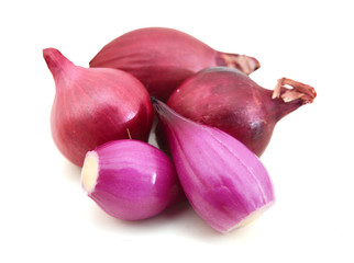 A group of small red pearl onions on a white background.