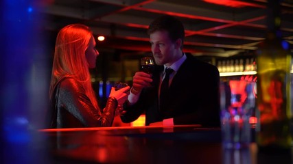 Couple drinking wine, man speaking to lady, capturing attention, pickup in club