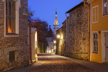 Night street and St. Olaf Baptist Church illuminated of Medieval Old Town in Tallinn, Estonia