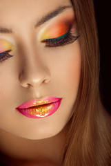 beautiful girl with glitter on her lips and multicolored eye shadows