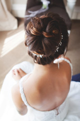 Portrait of attractive young woman with beautiful hairstyle and stylish hair accessory, rear view