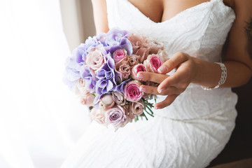 Wedding bouquet of the bride in hand. Beautiful wedding bouquet for bride. The bride touches her wedding bouquet. French manicure