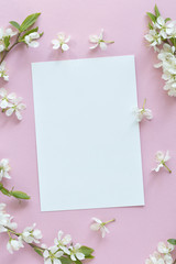 Spring concept. Flat-lay of blossom and card over light pink background, top view with space for your text