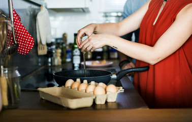 Caucasian woman coloking eggs in the kitchen