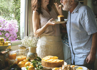 Lovely couple baking cheescake in the kitchen