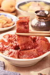 Braised pork with red yeast on the wooden table  