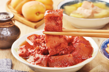 Braised pork with red yeast on the wooden table  