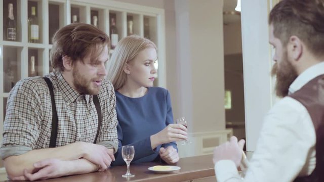 Attractive elegant young couple drinking a cocktail at the restaurant. Handsome loving couple flirting in a cafe. Love and romance. Lifestyle concept