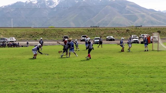 Boys 11-year-old youth lacrosse league play; player scores a goal