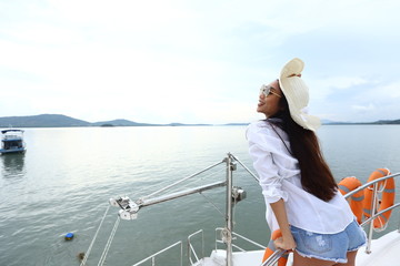 Fototapeta premium Asian Mix Race Tanned skin Woman Bikini Hat short jean stand on deck of Yacht Boat