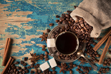 Cup of coffee with beans and cinnamon vintage still life