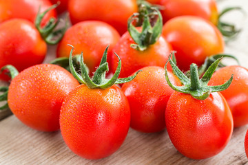 Fresh cherry tomatoes on rustic wooden background