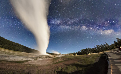 The Milky Way rising over Old Faithful erupting in Yellowstone National Park (Wyoming)