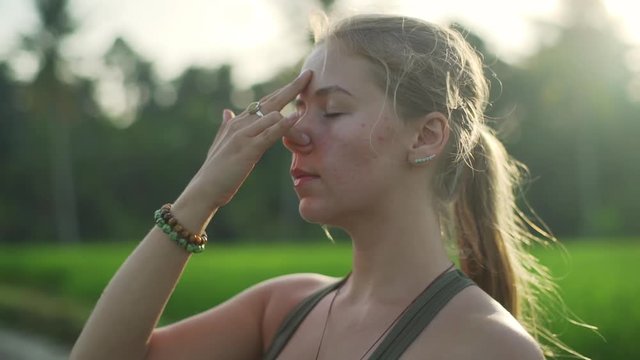Close up girl practice pranayama in rice field rapid at sunset slow motion