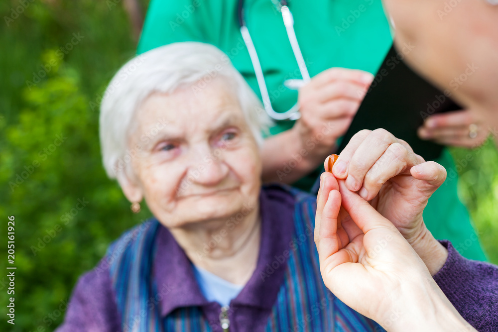 Poster elderly ill woman receiving pills