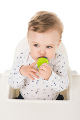 high angle view of little boy with baby pacifier sitting in highchair isolated on white background