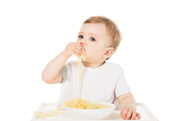 little boy in highchair eating spaghetti by hand isolated on white background