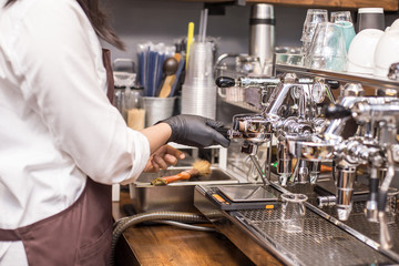 Barista using machine for make coffee at cafe.