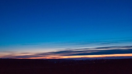 Late evening sky over village near fields