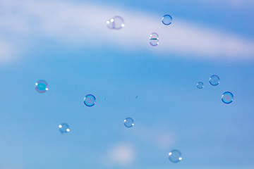Soap bubbles in flight against the sky